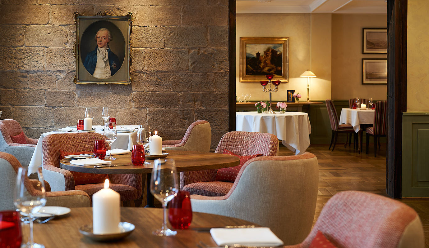 Zum Essen eingestellte Tische und Stühle im Restaurant Novalis