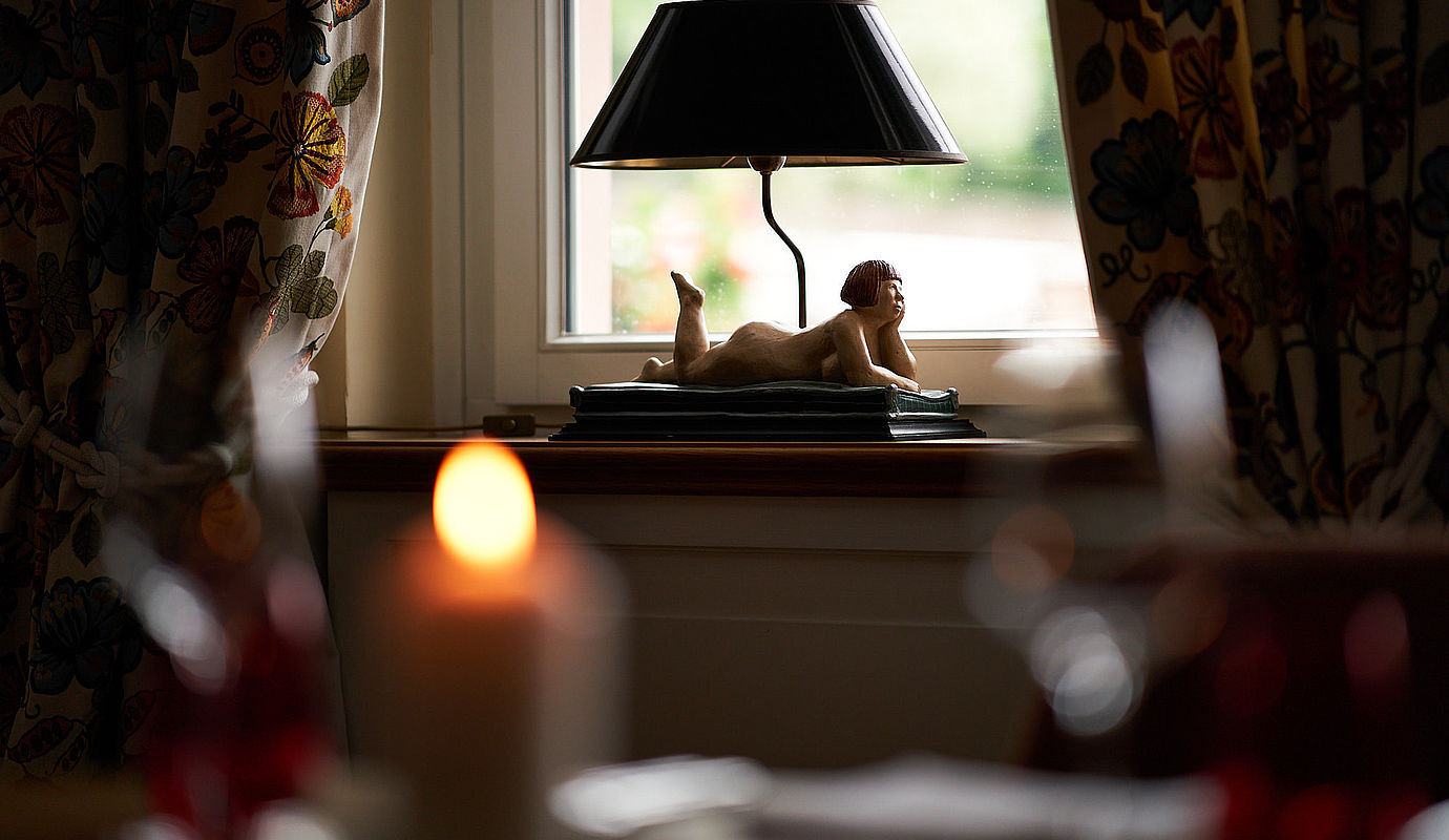 Eine Lampe in Form einer weiblichen Figur am Fenster im Hardenberg BurgHotel 