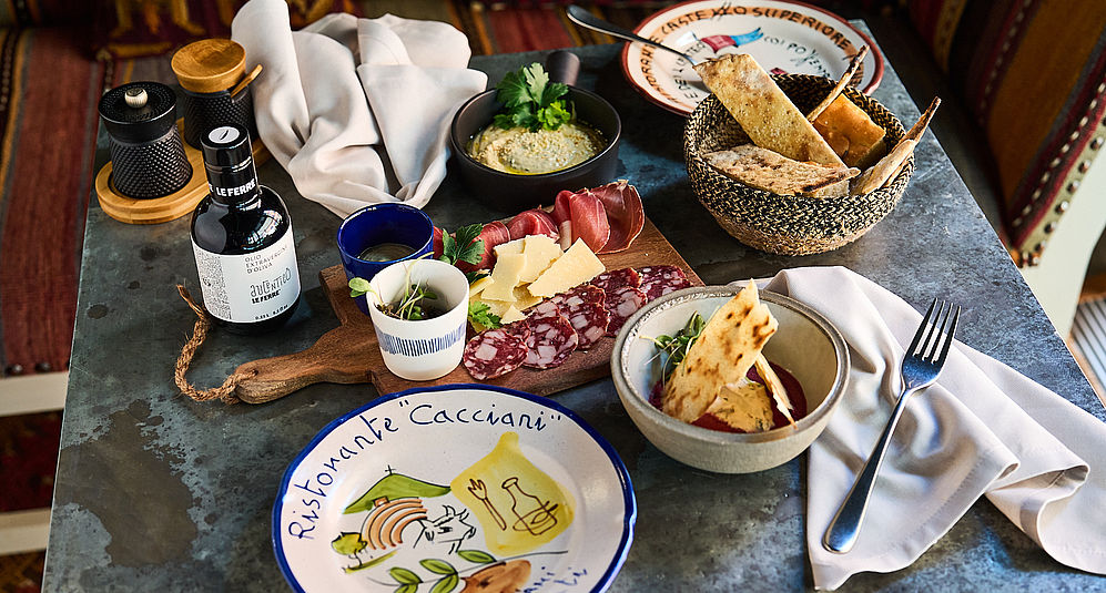 Nahaufnahme eines Frühstücks auf dem Tisch, bestehend aus getrockneter Salami, Käse und Brot